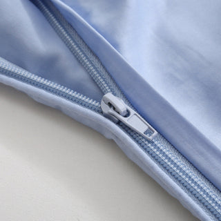 Close-up of a light blue fabric with a zipper on a neutral background