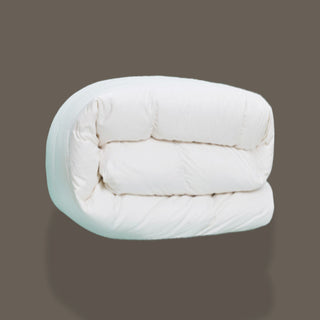 White quilted comforter on a gray background
