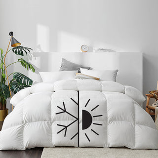 White comforter with temperature indicators for hot and cold on a bed in a bedroom setting