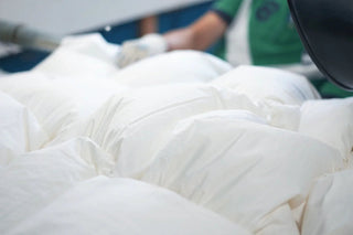 a fluffy duvet with worker's hands in the background