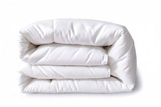 Folded white comforter on a white background