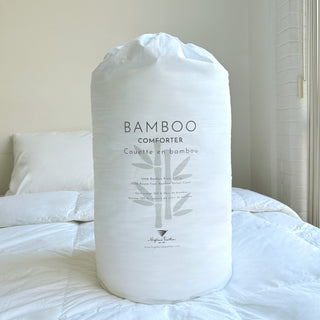 Bamboo comforter packaging on a bed with white bedding