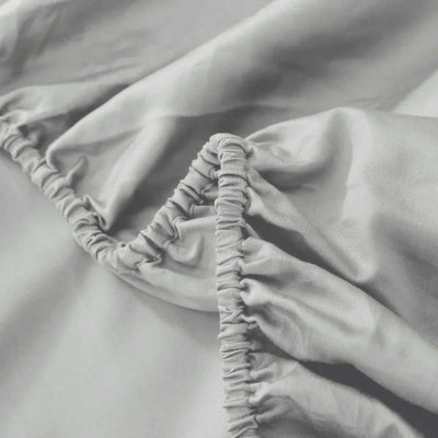 Close-up of a fitted sheet with elastic band on a bed.