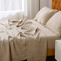 Beige bedspread and pillows on a bed in a bedroom setting