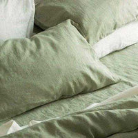 Sage green pillowcase on a white bedsheet